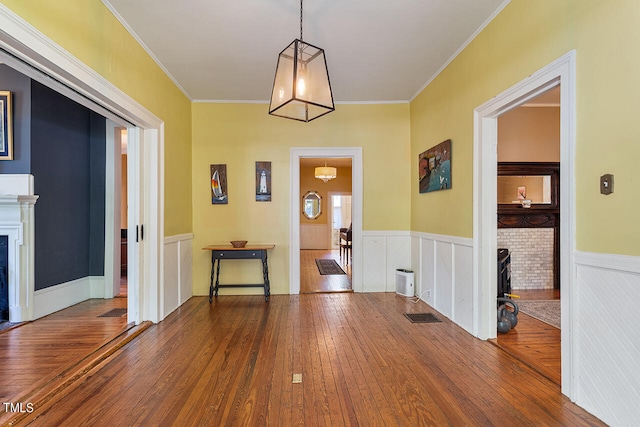 foyer featuring crown molding, a fireplace, and hardwood / wood-style floors