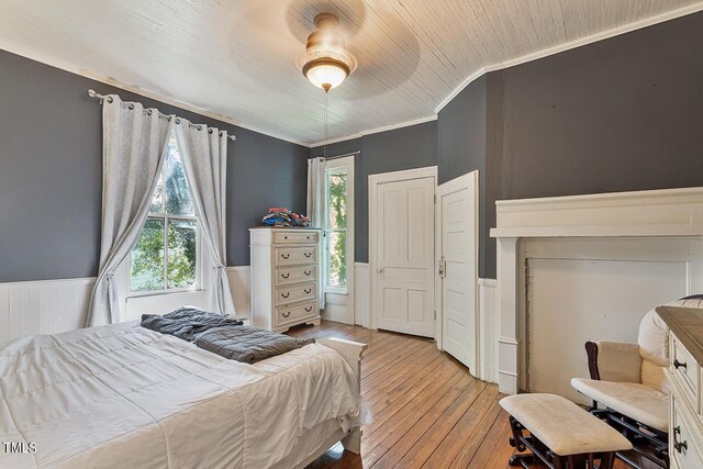 bedroom with multiple windows, crown molding, ceiling fan, and light hardwood / wood-style flooring