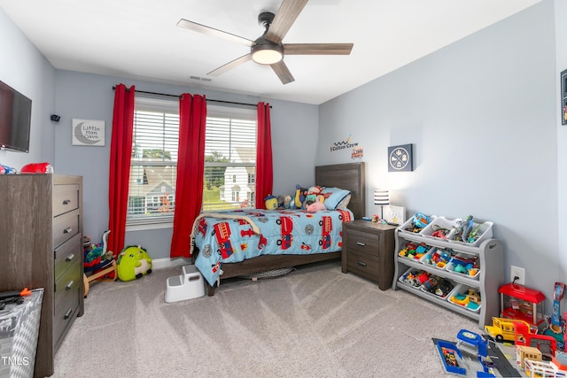 carpeted bedroom featuring a ceiling fan and visible vents