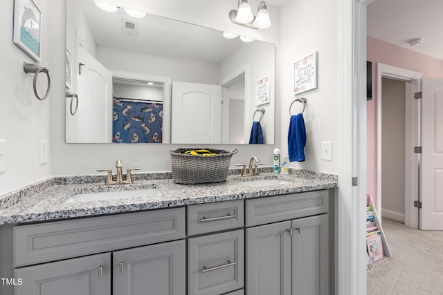 full bath with double vanity, visible vents, and a sink