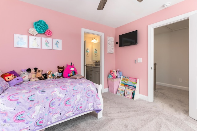 carpeted bedroom featuring ensuite bath, baseboards, and a ceiling fan