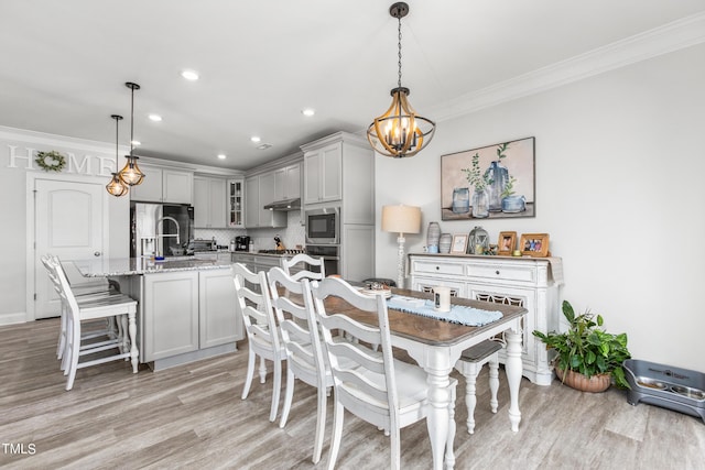 dining area with a chandelier, light wood-style flooring, recessed lighting, baseboards, and crown molding