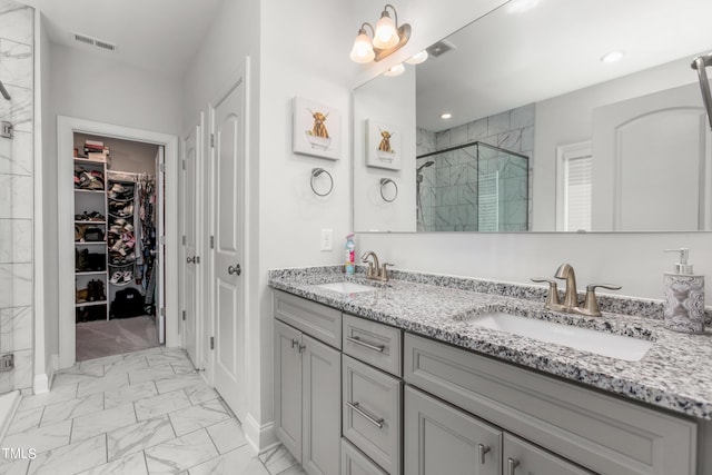 full bathroom featuring marble finish floor, visible vents, a sink, and a shower stall