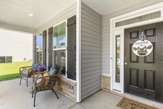 doorway to property featuring a yard and a porch