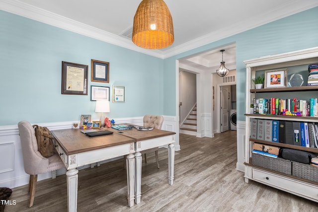 office area featuring washer / dryer, wainscoting, ornamental molding, wood finished floors, and a decorative wall