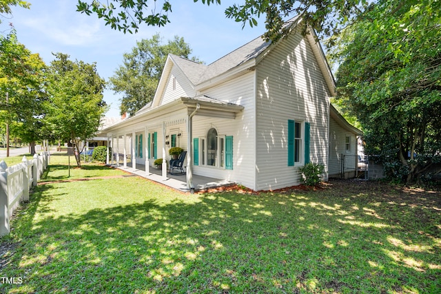 rear view of house featuring a yard and a patio area