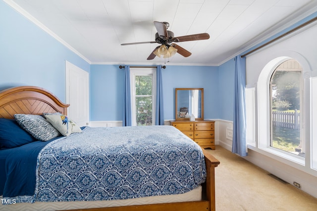 carpeted bedroom featuring ceiling fan and ornamental molding