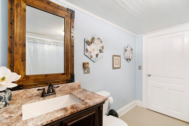 bathroom featuring toilet, crown molding, and vanity