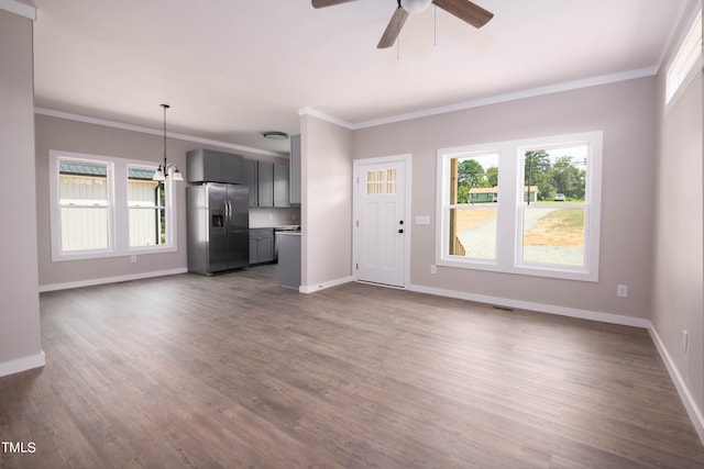 unfurnished living room featuring a wealth of natural light, ceiling fan, and wood-type flooring