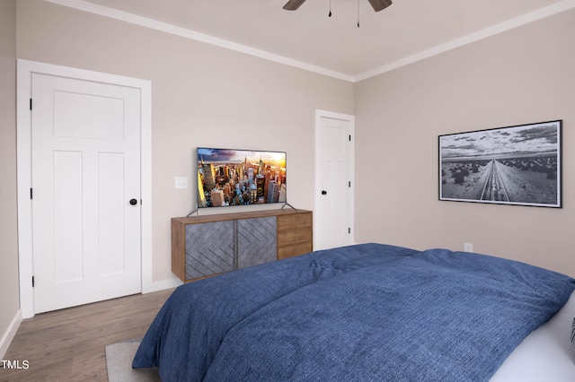 bedroom featuring ceiling fan, ornamental molding, and hardwood / wood-style flooring