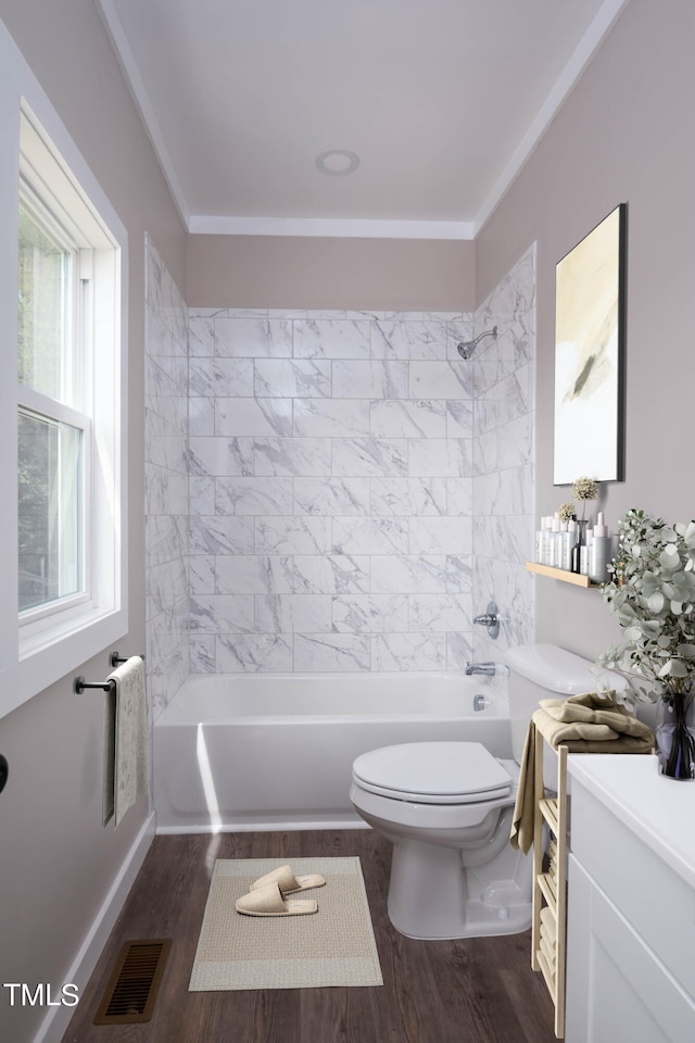 full bathroom with hardwood / wood-style floors, tiled shower / bath, and toilet