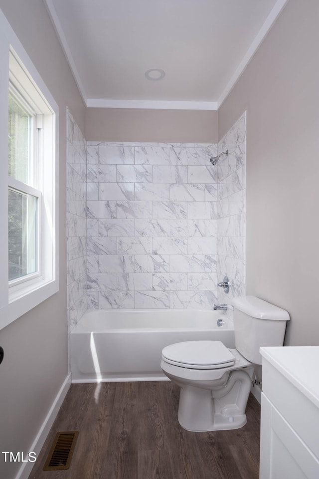 full bathroom featuring vanity, hardwood / wood-style floors, crown molding, toilet, and tiled shower / bath combo