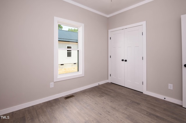 interior space with dark wood-type flooring, ornamental molding, and a healthy amount of sunlight