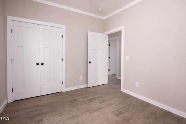 unfurnished bedroom featuring crown molding, hardwood / wood-style floors, and a closet