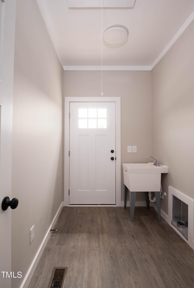 doorway to outside featuring ornamental molding and dark wood-type flooring