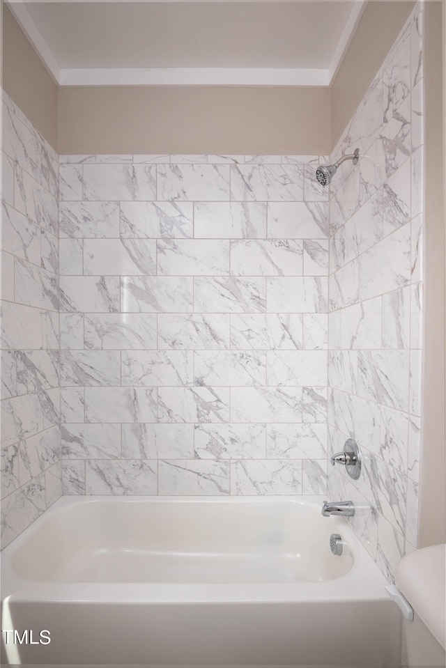 bathroom with tiled shower / bath combo and toilet