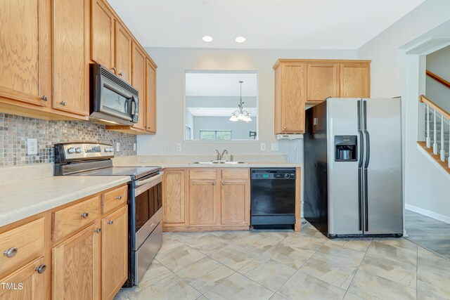 kitchen featuring tasteful backsplash, an inviting chandelier, black appliances, sink, and decorative light fixtures