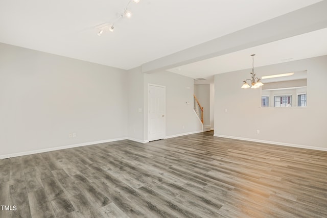 unfurnished room featuring a chandelier, hardwood / wood-style flooring, and rail lighting