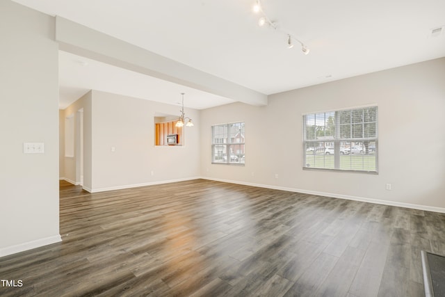 empty room with dark hardwood / wood-style flooring and a chandelier