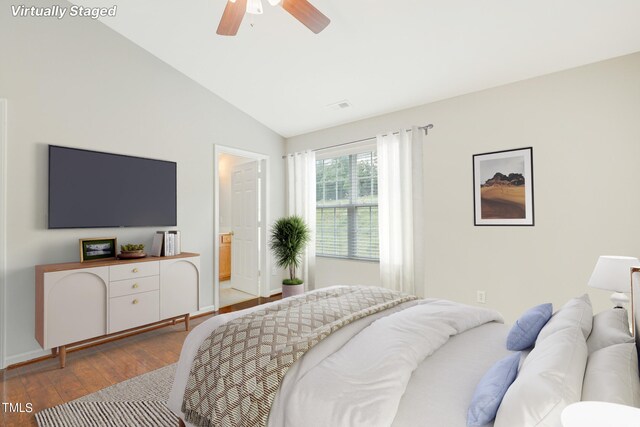 bedroom with lofted ceiling, ensuite bath, hardwood / wood-style flooring, and ceiling fan