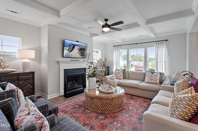 living room with beam ceiling, ceiling fan, coffered ceiling, crown molding, and wood-type flooring