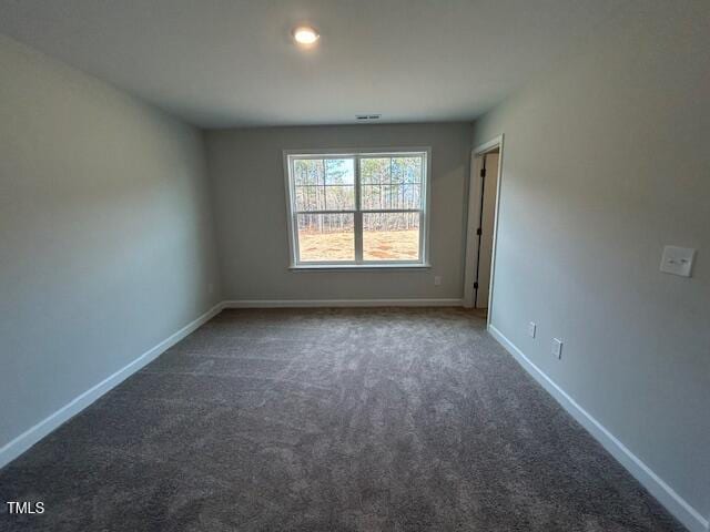 unfurnished room featuring dark carpet