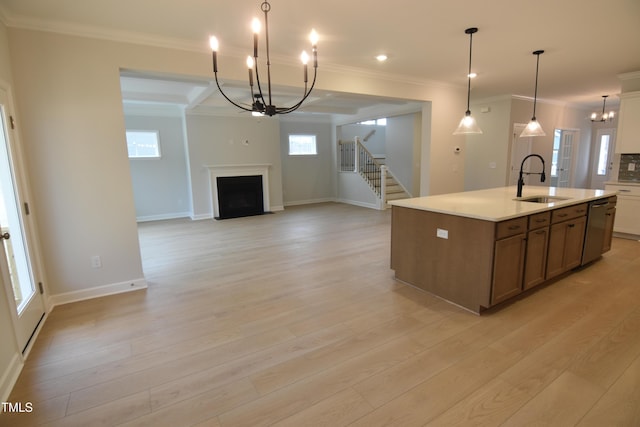 kitchen with dishwasher, an island with sink, a chandelier, and sink