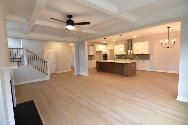 unfurnished living room featuring beamed ceiling, coffered ceiling, and sink