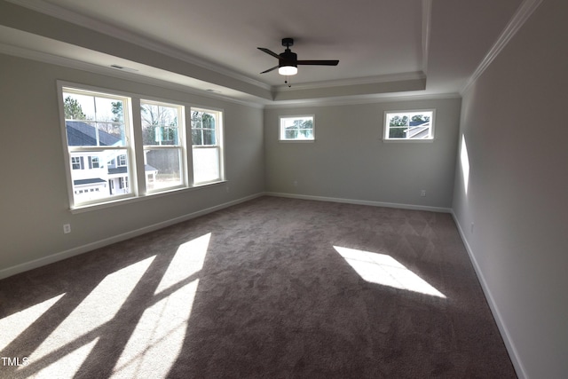 carpeted empty room featuring ceiling fan, ornamental molding, and a tray ceiling