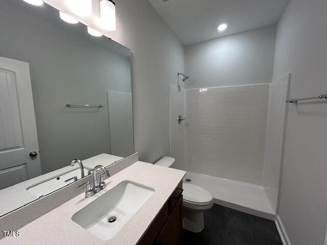 bathroom featuring vanity, toilet, and walk in shower