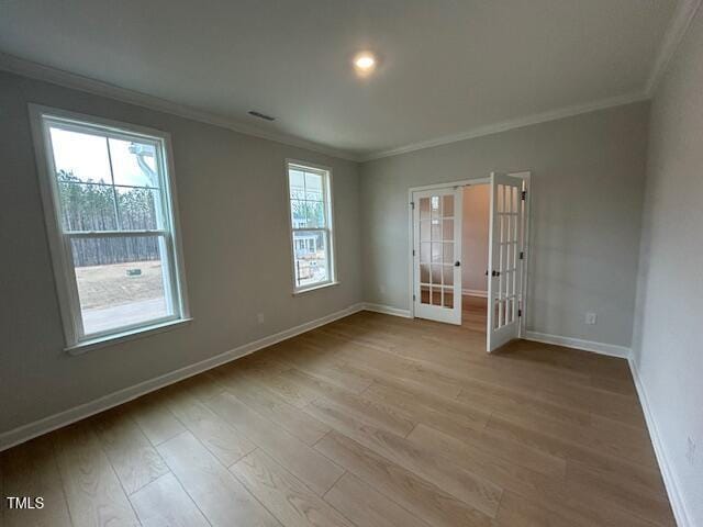 spare room featuring light hardwood / wood-style floors, ornamental molding, and french doors