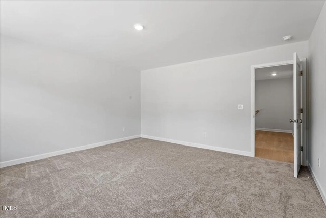 unfurnished room with recessed lighting, baseboards, and light colored carpet