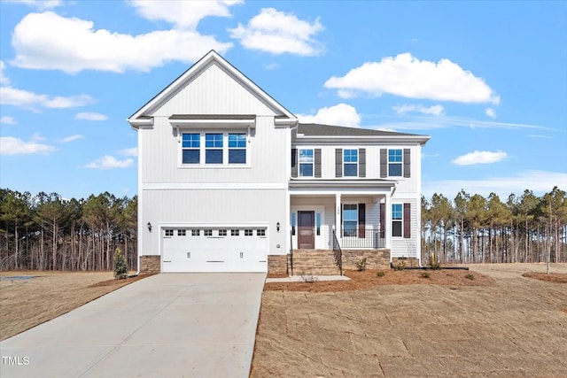 view of front of home featuring driveway, covered porch, and an attached garage