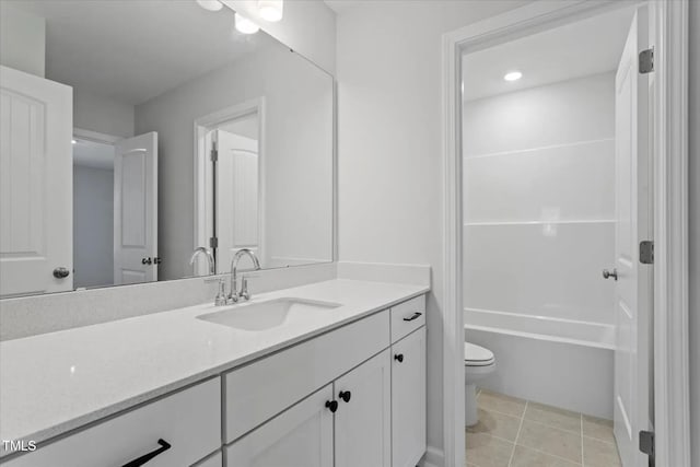 bathroom with toilet, vanity, and tile patterned floors