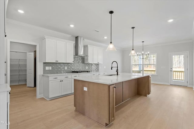 kitchen with a spacious island, white cabinets, and wall chimney exhaust hood