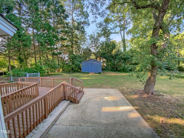 view of yard featuring a storage unit, a wooden deck, and a patio area