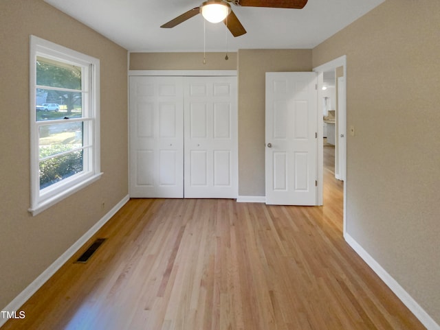 unfurnished bedroom with ceiling fan, a closet, and light hardwood / wood-style floors