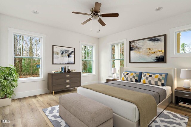 bedroom featuring multiple windows, ceiling fan, and light hardwood / wood-style floors