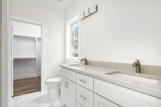 bathroom with toilet, a wealth of natural light, hardwood / wood-style flooring, and vanity