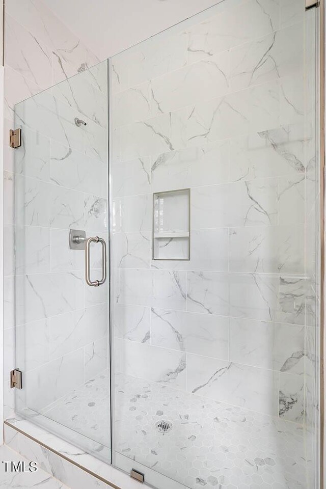 bathroom featuring a shower with shower door