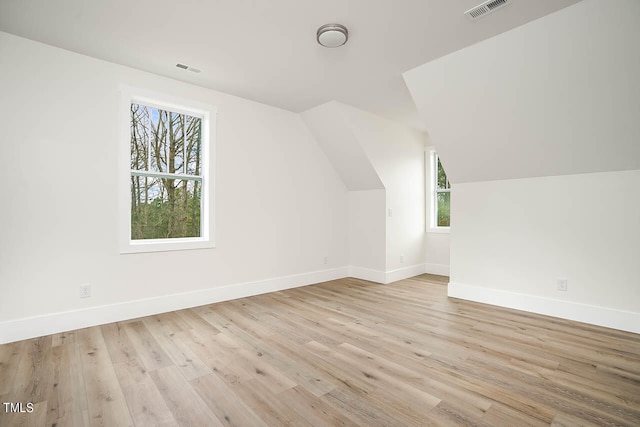 additional living space with vaulted ceiling and light wood-type flooring