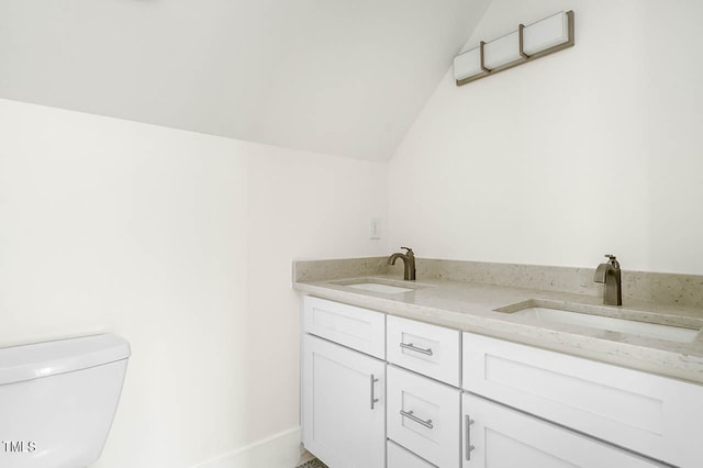 bathroom with vanity, toilet, and vaulted ceiling