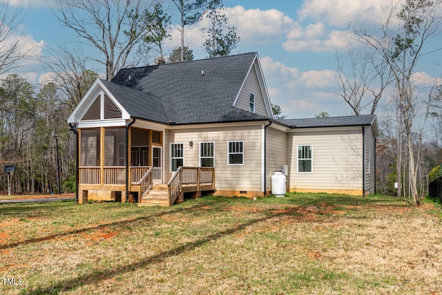 back of property with a sunroom and a lawn