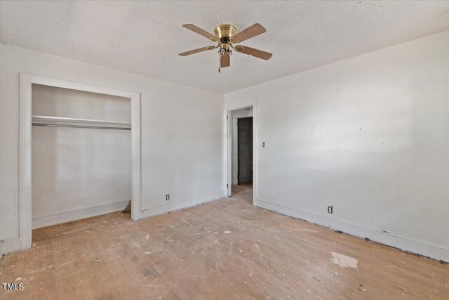 unfurnished bedroom with a textured ceiling, ceiling fan, and a closet