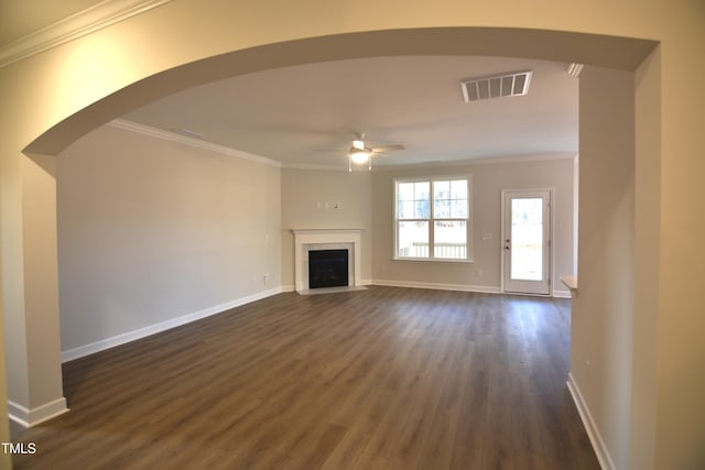 unfurnished living room featuring visible vents, baseboards, a ceiling fan, ornamental molding, and dark wood finished floors