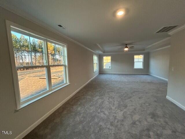 carpeted empty room featuring baseboards, visible vents, and crown molding