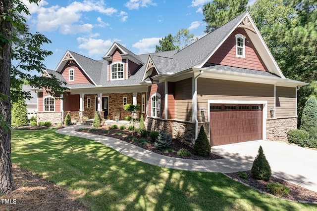 craftsman house featuring a garage and a front lawn