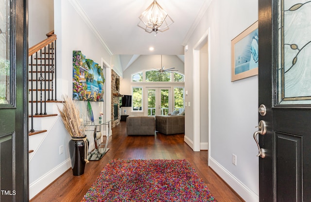 foyer entrance featuring an inviting chandelier, crown molding, french doors, lofted ceiling, and dark wood-type flooring