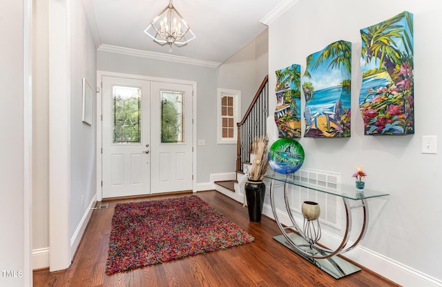 entryway with crown molding, baseboards, stairs, wood finished floors, and a notable chandelier
