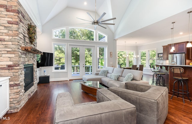 living room with a fireplace, high vaulted ceiling, crown molding, dark hardwood / wood-style flooring, and ceiling fan